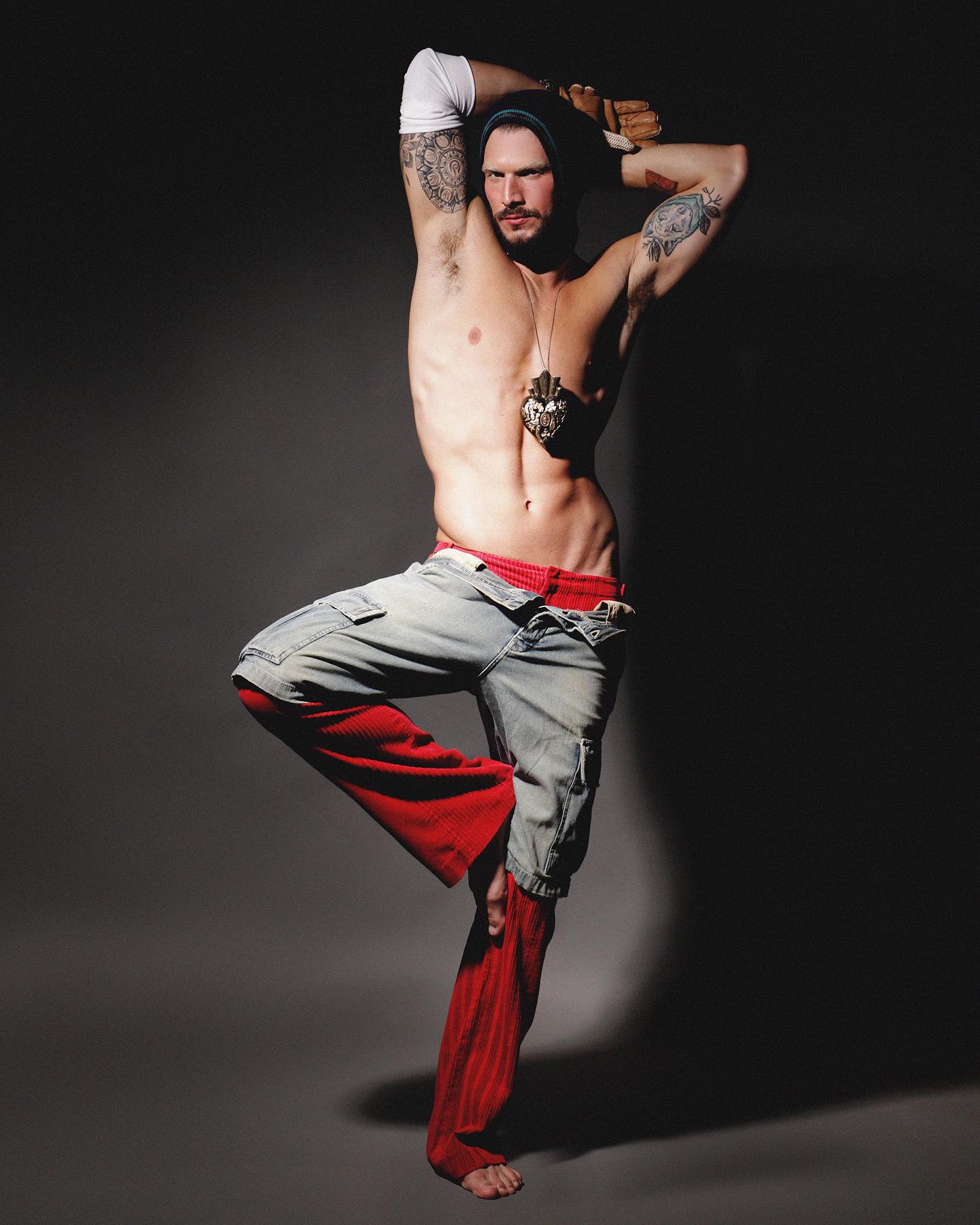 Alex Trevelin em editorial com styling de Michael Juvêncio, calça vermelha e denim sobre fundo escuro