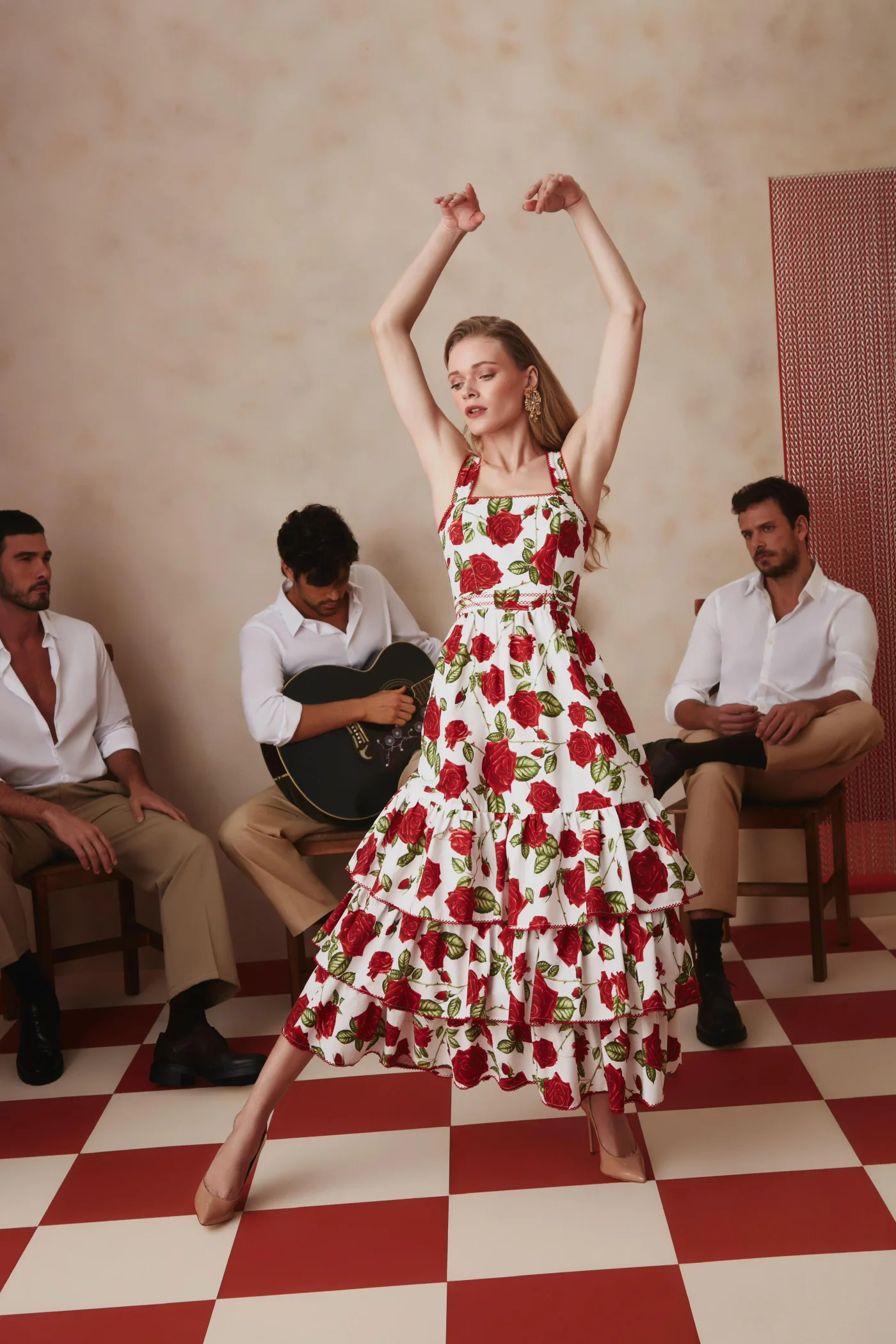 Thais Custodio em vestido branco com rosas vermelhas cercada por modelos masculinos