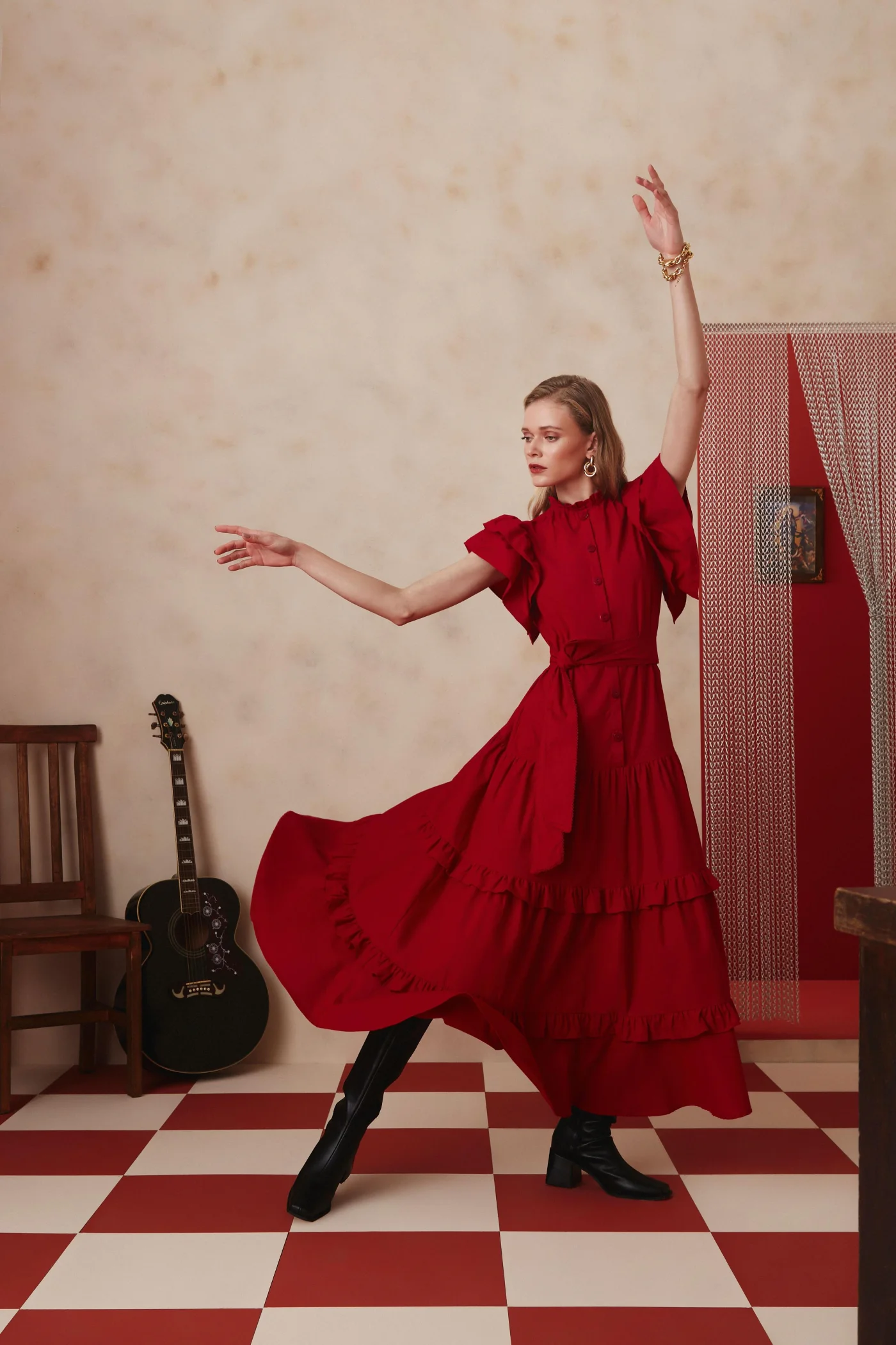 Thais Custodio em vestido vermelho em pose de dança no editorial Lalibela