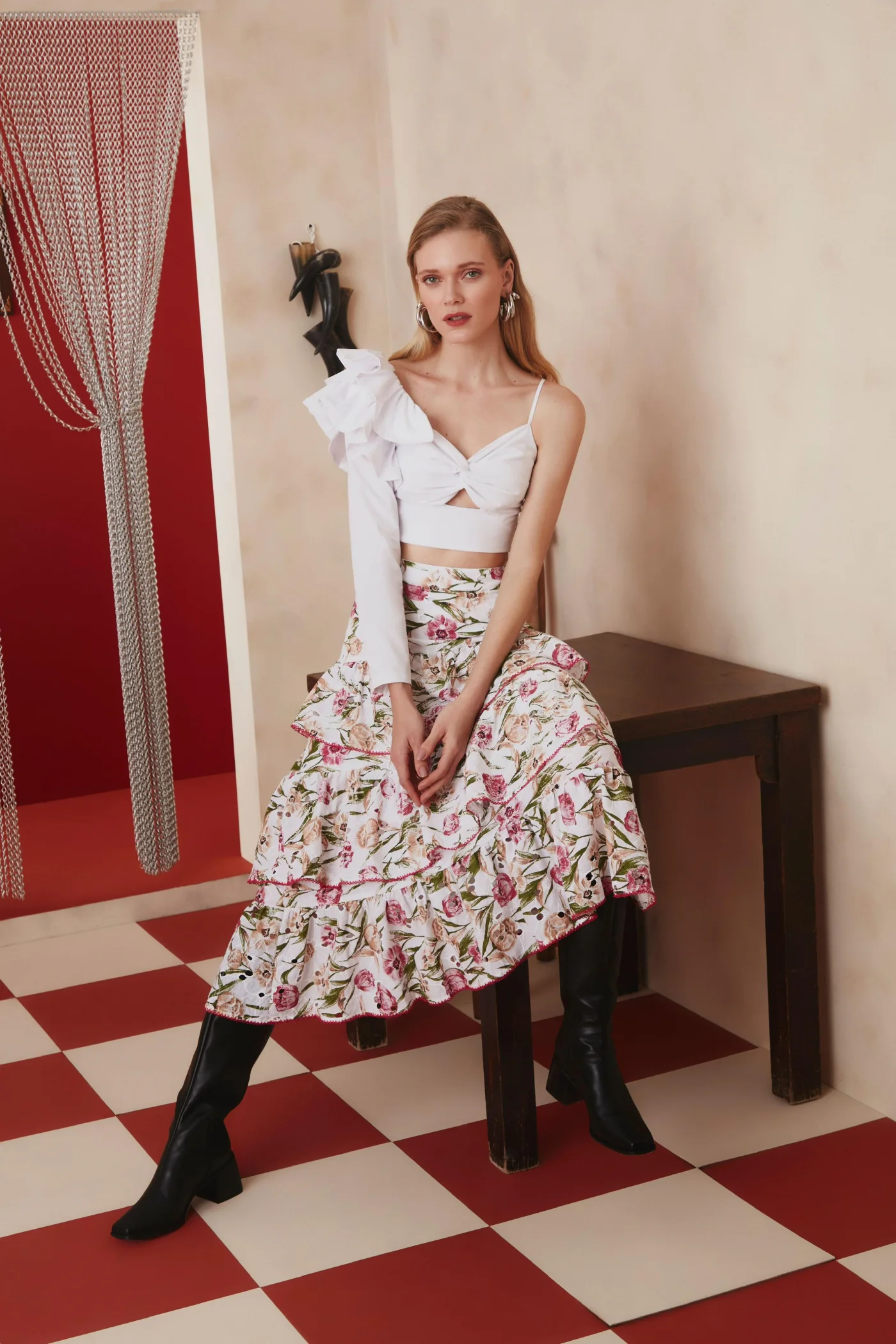 Thais Custodio sentada com saia floral e top branco para Lalibela