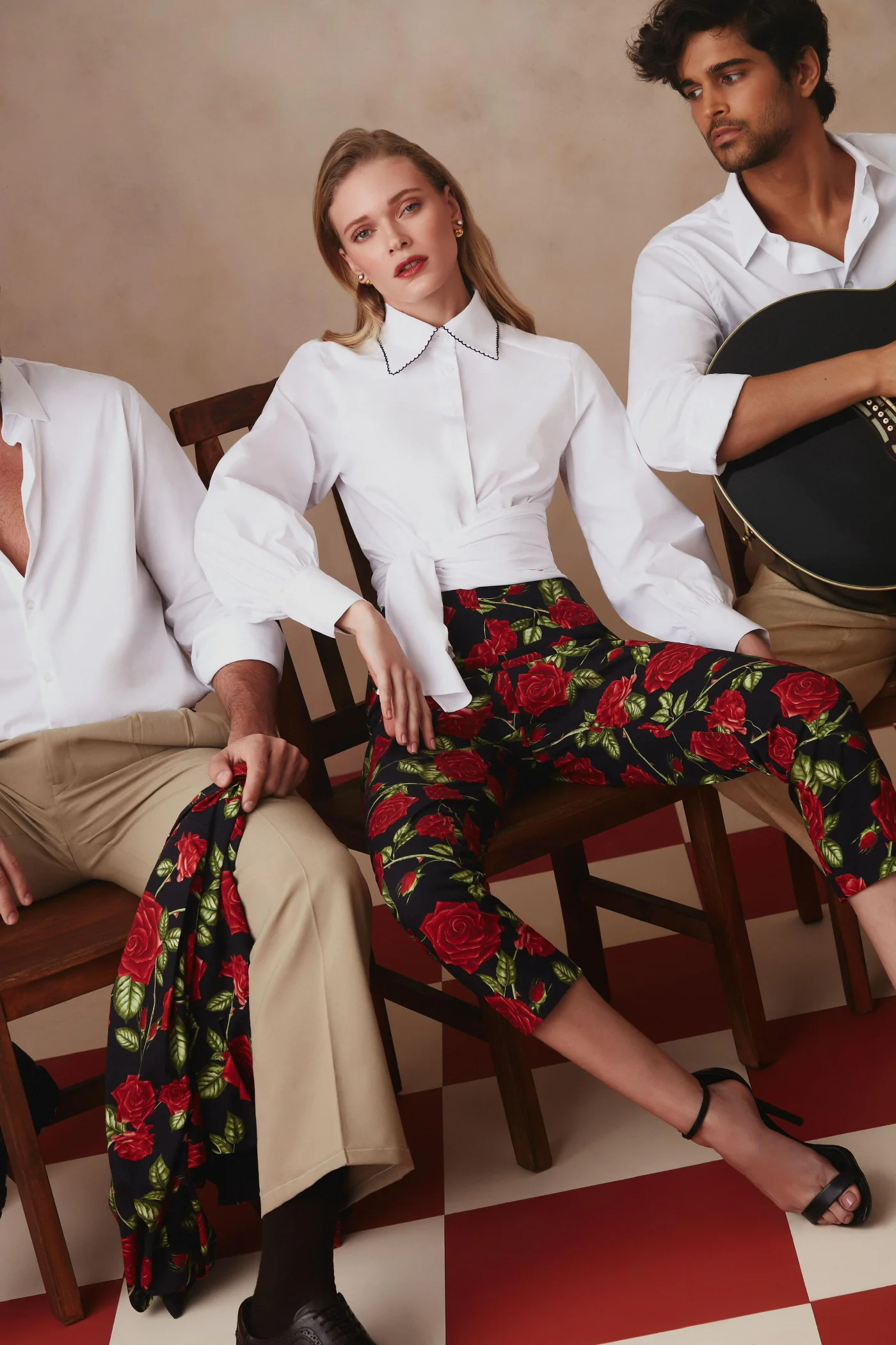 Thais Custodio em camisa branca e calça floral com modelos e violão