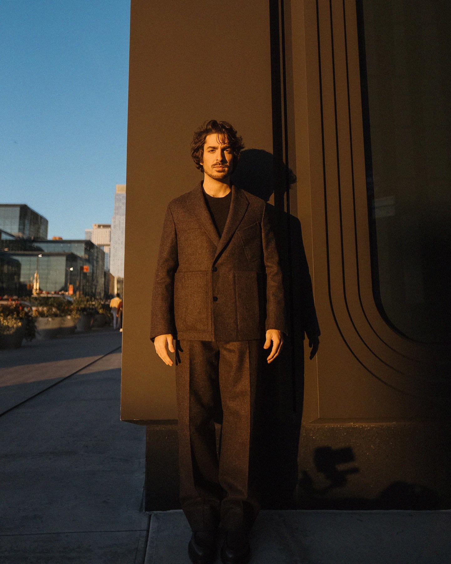 Rafael Gasparini em Zegna AW24 diante de arquitetura urbana