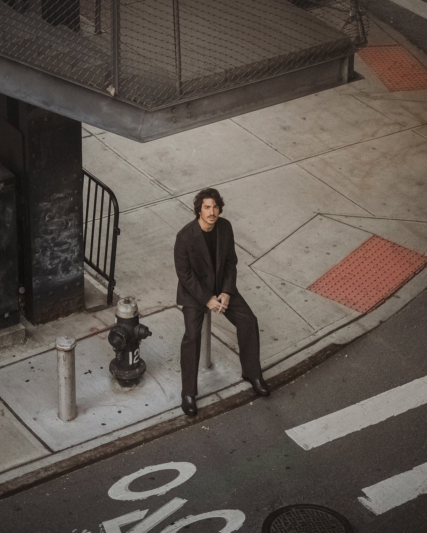 Rafael Gasparini sentado em cenário urbano para Zegna AW24