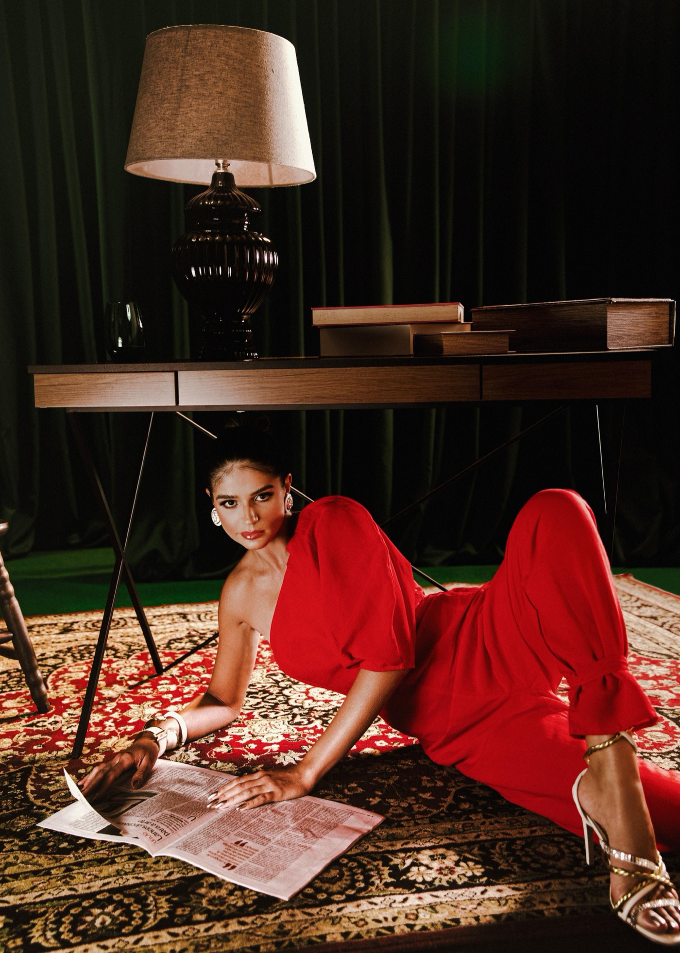 Thássia Naves em look vermelho deitada sobre tapete em campanha Colcci